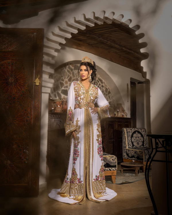 CAFTAN EXPORT Découvrez l'élégance intemporelle du caftan henna, une pièce traditionnelle marocaine magnifiquement ornée. Nos caftans en henna allient beauté et tradition pour des moments inoubliables. Explorez notre collection unique aujourd'hui ! Magnifique caftan en crêpe de soie, brodé et perlé à la main avec des perles en cristal roses, vertes et fuchsia. Le bas du caftan est également en drap de soie, brodé et perlé à la main. Livré avec une ceinture en métal doré.