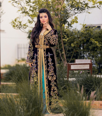 CAFTAN EXPORT Découvrez l'élégance intemporelle du caftan henna, une pièce traditionnelle marocaine magnifiquement ornée. Nos caftans en henna allient beauté et tradition pour des moments inoubliables. Explorez notre collection unique aujourd'hui ! Le caftan se compose de deux pièces en crêpe de soie vert, ornées de broderies dorées, de perles en cristal, de sfifa et de boutons en skali doré. La partie inférieure est confectionnée en drap de soie vert, perlé à la main. Il est accompagné d'une ceinture assortie en métal.