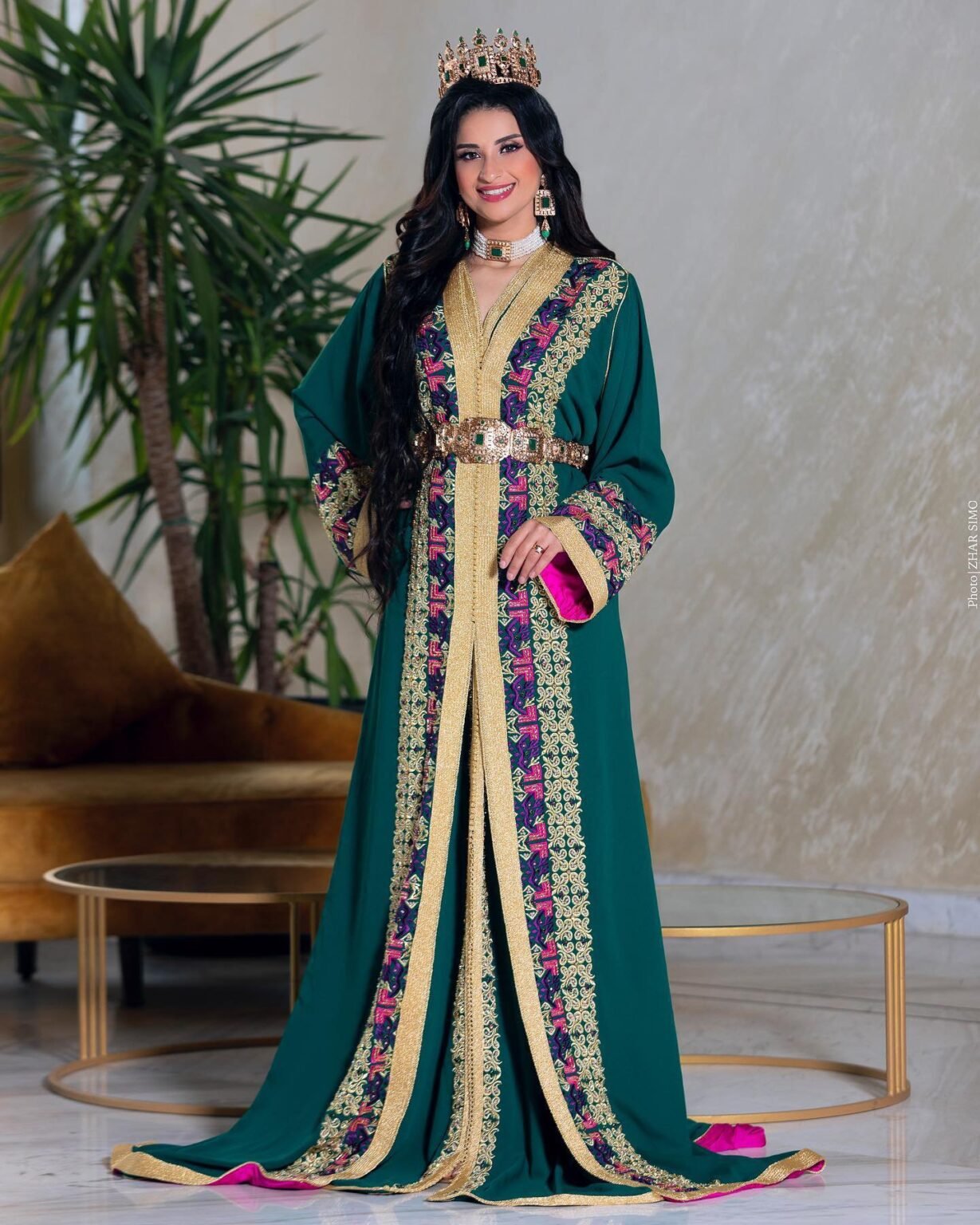 CAFTAN EXPORT Découvrez l'élégance intemporelle du caftan henna, une pièce traditionnelle marocaine magnifiquement ornée. Nos caftans en henna allient beauté et tradition pour des moments inoubliables. Explorez notre collection unique aujourd'hui ! Le caftan Rayhana se compose de deux pièces en crêpe de soie vert, ornées de broderies dorées et rose fushia, de perles en cristal, de sfifa et de boutons en skali doré, doublé en satin de soie fushia. La partie inférieure est confectionnée en drap de soie vert, perlé à la main. Il est accompagné d'une ceinture assortie en métal.