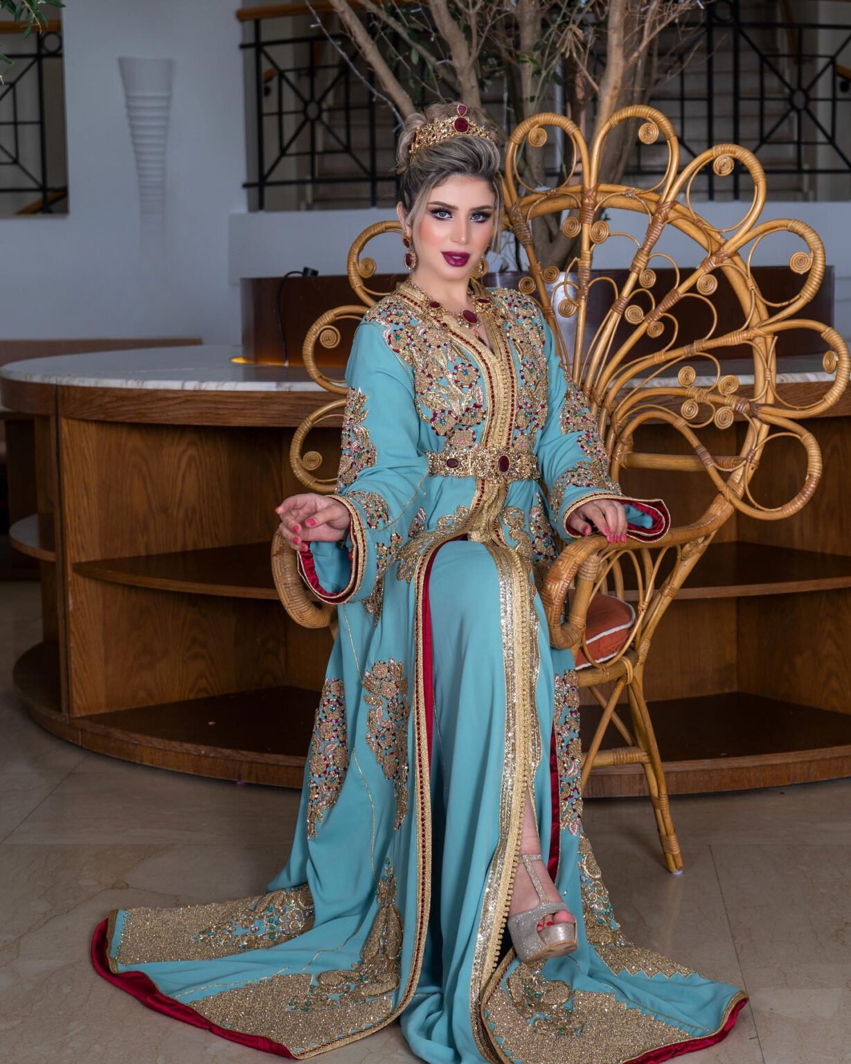 CAFTAN EXPORT Découvrez l'élégance intemporelle du caftan henna, une pièce traditionnelle marocaine magnifiquement ornée. Nos caftans en henna allient beauté et tradition pour des moments inoubliables. Explorez notre collection unique aujourd'hui ! Le caftan Kaoutar est composé de deux pièces en crêpe de soie bleu, ornées de broderies dorées, de sfifa et de boutons en skali doré. Il est doublé en satin de soie rouge. La partie inférieure est un caftan sans manches, confectionné en drap de soie bleu et perlé à la main. Il est accompagné d'une ceinture assortie en métal.