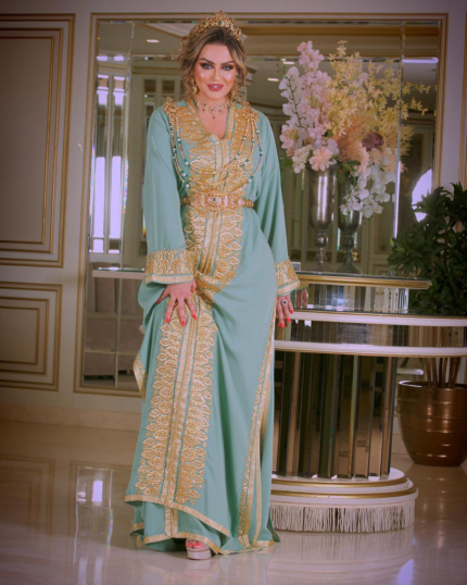 CAFTAN EXPORT Découvrez l'élégance intemporelle du caftan henna, une pièce traditionnelle marocaine magnifiquement ornée. Nos caftans en henna allient beauté et tradition pour des moments inoubliables. Explorez notre collection unique aujourd'hui ! Le caftan sirene, composé de deux pièces en crêpe de soie blanc, travaillé en zewak maalam, sfifa et button en skali doré. Le bas est confectionné en draps de soie blanc, Il est accompagné d'une ceinture assortie en metal.