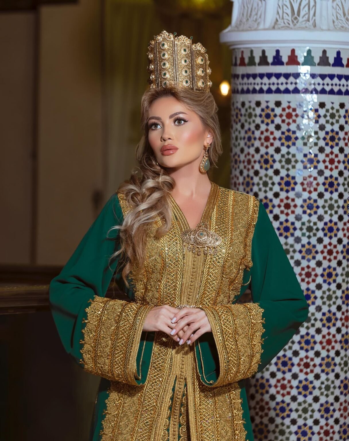 CAFTAN EXPORT Découvrez l'élégance intemporelle du caftan henna, une pièce traditionnelle marocaine magnifiquement ornée. Nos caftans en henna allient beauté et tradition pour des moments inoubliables. Explorez notre collection unique aujourd'hui ! Le caftan Chahinaz est composé de deux pièces en crêpe de soie vert, ornées de broderies dorées, de sfifa et de boutons en skali doré. La partie inférieure est un caftan confectionné en drap de soie vert et perlé à la main. Il est accompagné d'une ceinture assortie en métal.