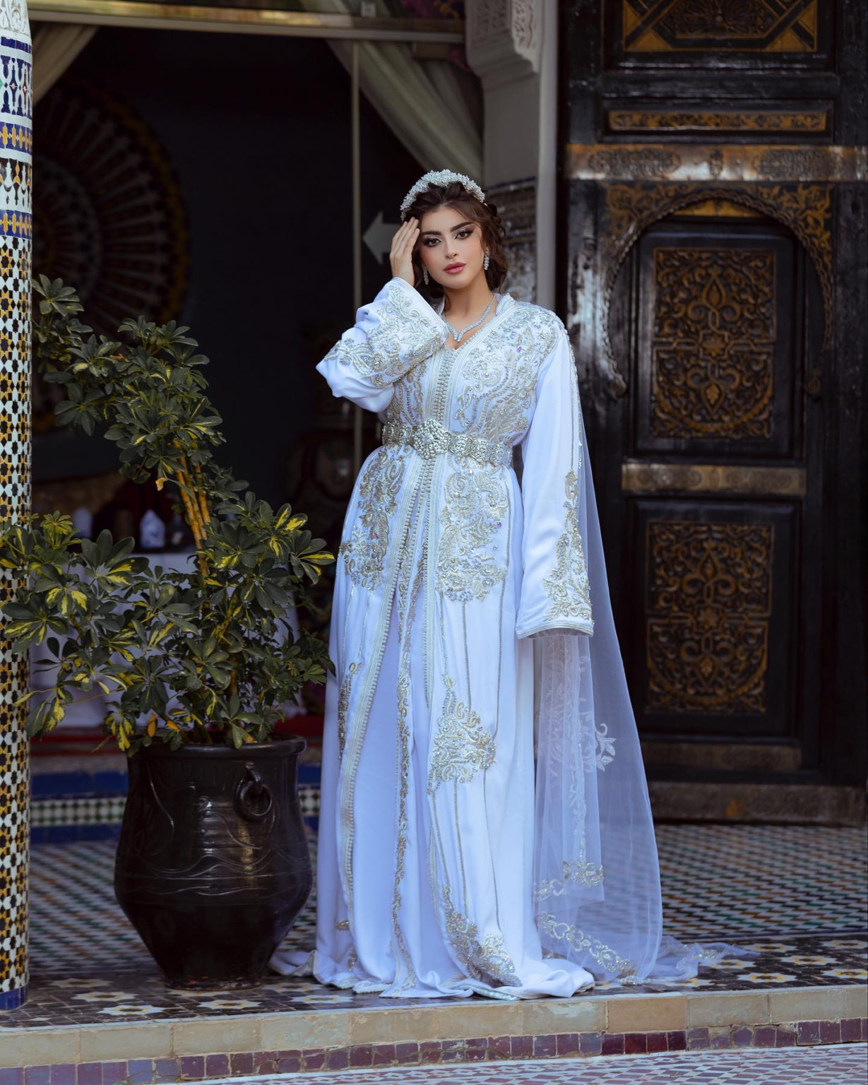 CAFTAN EXPORT Découvrez l'élégance intemporelle du caftan henna, une pièce traditionnelle marocaine magnifiquement ornée. Nos caftans en henna allient beauté et tradition pour des moments inoubliables. Explorez notre collection unique aujourd'hui ! Caftan de mariage en crêpe de soie blanc, brodé en argent et perlé à la main. Le bas en drap de soie est également brodé et perlé à la main, livré avec une ceinture assortie en métal argenté.